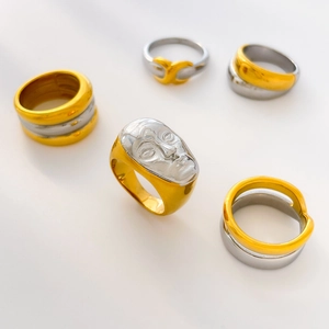 Detailed view of mixed metal hollow rings and artistic facial relief on steel bands