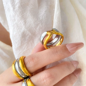 Two-tone layered twisted stainless steel ring shown on hand with minimalist gold and silver finish