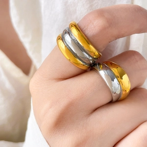 Detail of two-tone layered hollow rings in gold and silver finish worn on fingers