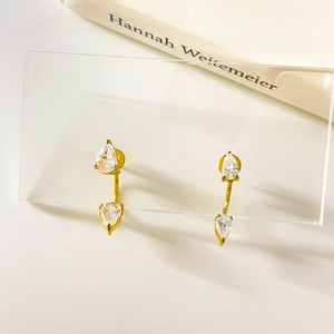 Vista macro de pendientes de arco dorados con dos circonitas transparentes talla pera