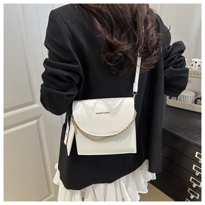 Close-up of white textured crossbody bag with gold chain and mini coin pouch detail