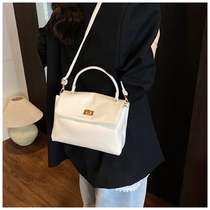 Detail view of cream white soft faux leather crossbody bag with elegant gold metal lock