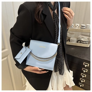Detail of light blue crossbody square bag with gold chain and mini coin pouch accessory