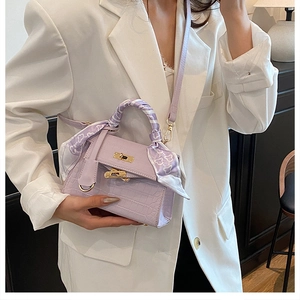 Detail of light purple crocodile embossed Kelly bag with silk scarf on handle