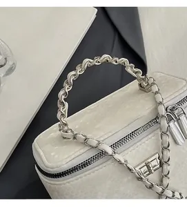 Detail of white snake-patterned chain handbag with silver hardware and zipper closure