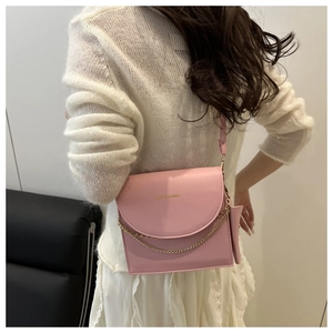 Pink chain crossbody bag with mini pouch shown from back side on female model