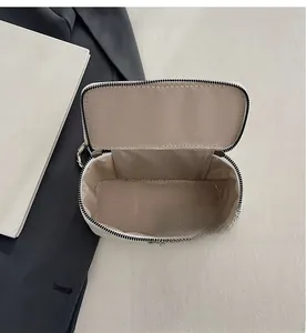 Interior detail of white leather vanity case with chevron lining and dual zipper design