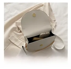 Interior view showing capacity of white flap crossbody bag with gold chain and coin purse