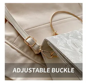 Close-up of golden adjustable buckle on white floral jacquard lace handbag strap