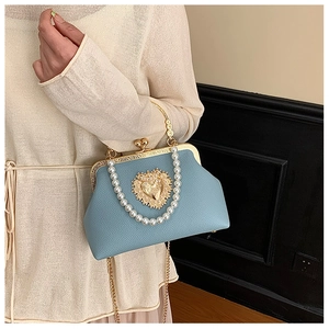 Close-up of vintage light blue shell bag with pearl handle and golden heart buckle