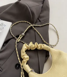 Detail of cream pleated cloud bag featuring soft texture and stylish metal chain strap