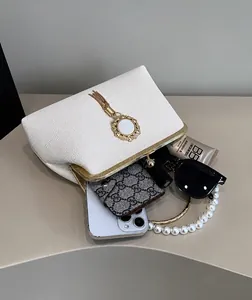 Interior view of white shell bag showing capacity for phone, lipstick, and sunglasses