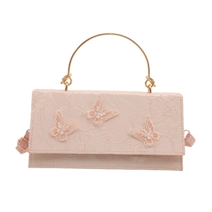 Pink lace handbag with butterfly embroidery and golden circular handle, 45-degree angle