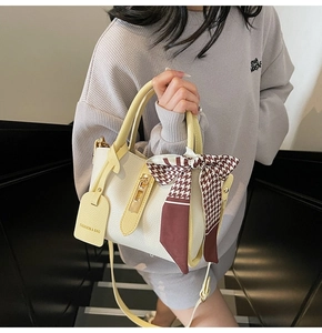 Dettaglio borsa a mano bicolore crema e giallo con foulard di seta a pied-de-poule chic