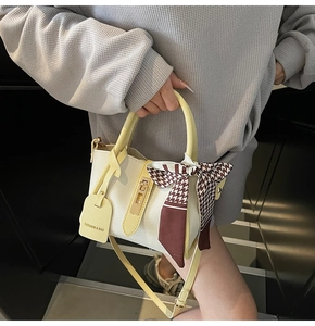 Dettaglio borsa in pelle martellata con foulard pied de poule e chiusura in metallo