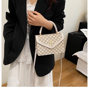 Detail of beige monogram shoulder bag with gold twist lock and elegant top handle