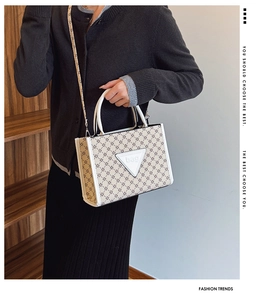 Detail view of large capacity tote bag featuring elegant monogram print and triangle patch