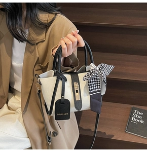 Dettaglio borsa bianca in pelle trama litchi con foulard in seta pied de poule