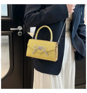 Détail du sac à main doré pailleté avec boucle de nœud en strass argentés pour femmes