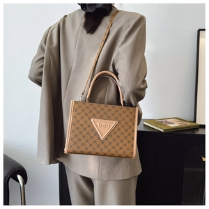 Brown monogram tote bag detail with triangle embossed logo and adjustable strap