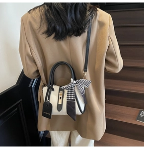 Dettaglio borsa in pelle litchi bianco con chiusura in metallo dorato e foulard in seta