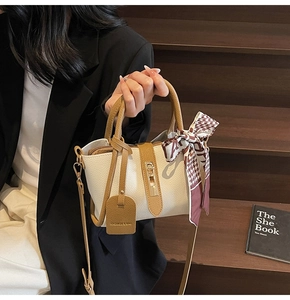 Dettaglio della borsa elegante con foulard di seta su fondo in legno