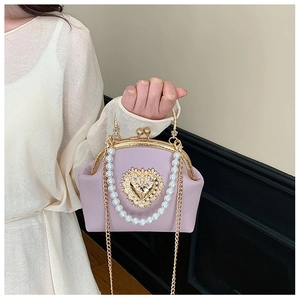 Close-up of pearl handle and golden heart relief on lavender leather shell bag