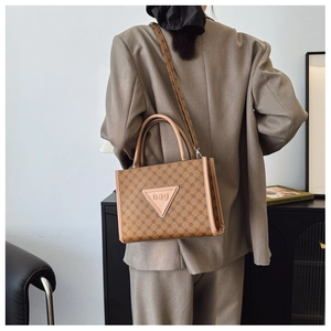 Detail of vintage brown tote bag with geometric pattern and triangular brand patch