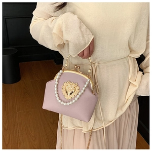 Close-up of heart metal detail and pearl handle on lavender leather shell bag