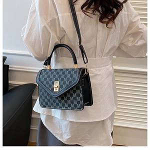 Detail of a chic mini crossbody bag with repeated M patterns and golden lock clasp
