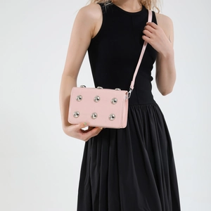 Pink punk-style quilted crossbody bag with silver metal studs and thin shoulder strap