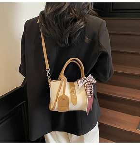 Dettaglio cuciture a contrasto, manico con foulard e pelle martellata della borsa