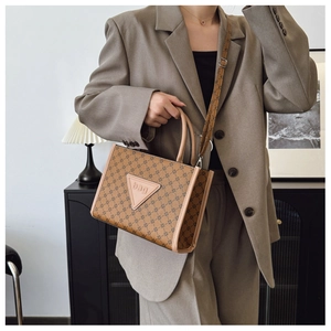 Detailed view of tote bag featuring vintage geometric print and leather logo patch