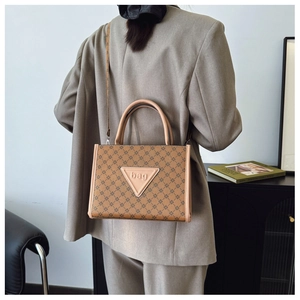 Close-up of beige leather tote bag with geometric patterns and a triangle brand label