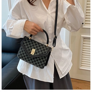 Detail of monogram shoulder bag with gold twist lock and black leather handle