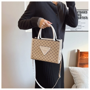 Detail of printed tote bag featuring a star pattern and white handle with bag logo