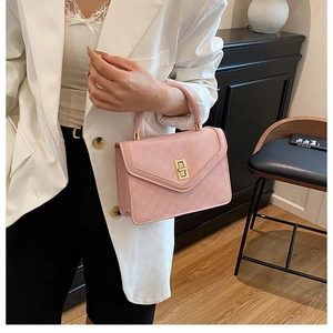 Close-up of pink leather handbag featuring a gold rectangle twist lock and litchi texture