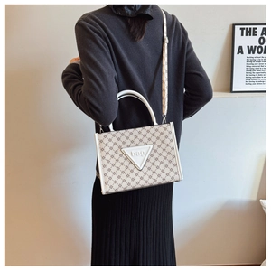 Detail of the chic beige tote bag showing textured print and dual handle straps
