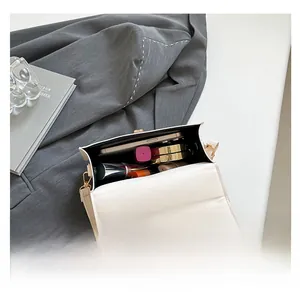 Internal capacity of the cream leather handbag showing phone and makeup storage