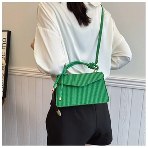 Détail du sac bandoulière tissé vert vif avec bandoulière nouée et aspect texturé