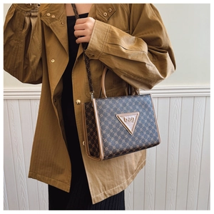 Detail of vintage brown tote bag with geometric pattern and adjustable shoulder strap