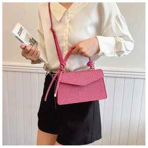 Détail du sac à rabat rose fuchsia tissé avec bandoulière à nœud élégante