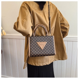 Detailed back view of a large vintage monogram tote bag styled with casual brown outerwear