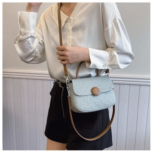Detail showing light blue embossed PU leather handbag with brown round decorative buckle