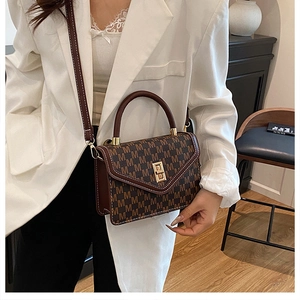Detail of vintage brown monogram handbag with gold twist lock and leather shoulder strap