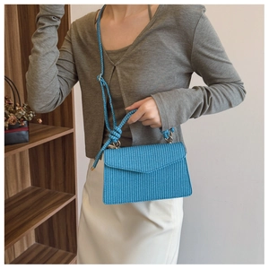 Détail du sac bandoulière tissé bleu montrant la texture et la bandoulière en corde