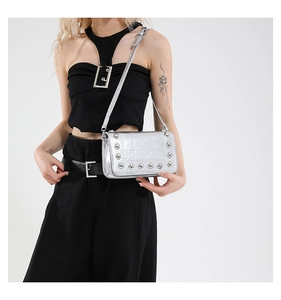 Dettaglio borsa punk argento metallizzato con borchie e motivo geometrico trapuntato