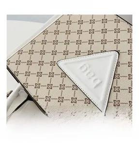 Macro shot of geometric print tote bag with triangle leather logo patch and fine stitching