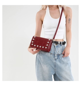Dettaglio della borsa punk rossa con borchie argentate e cuciture geometriche