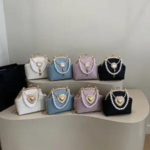 Elegant shell bag with pearl handle and heart clasp in four colors on display stand
